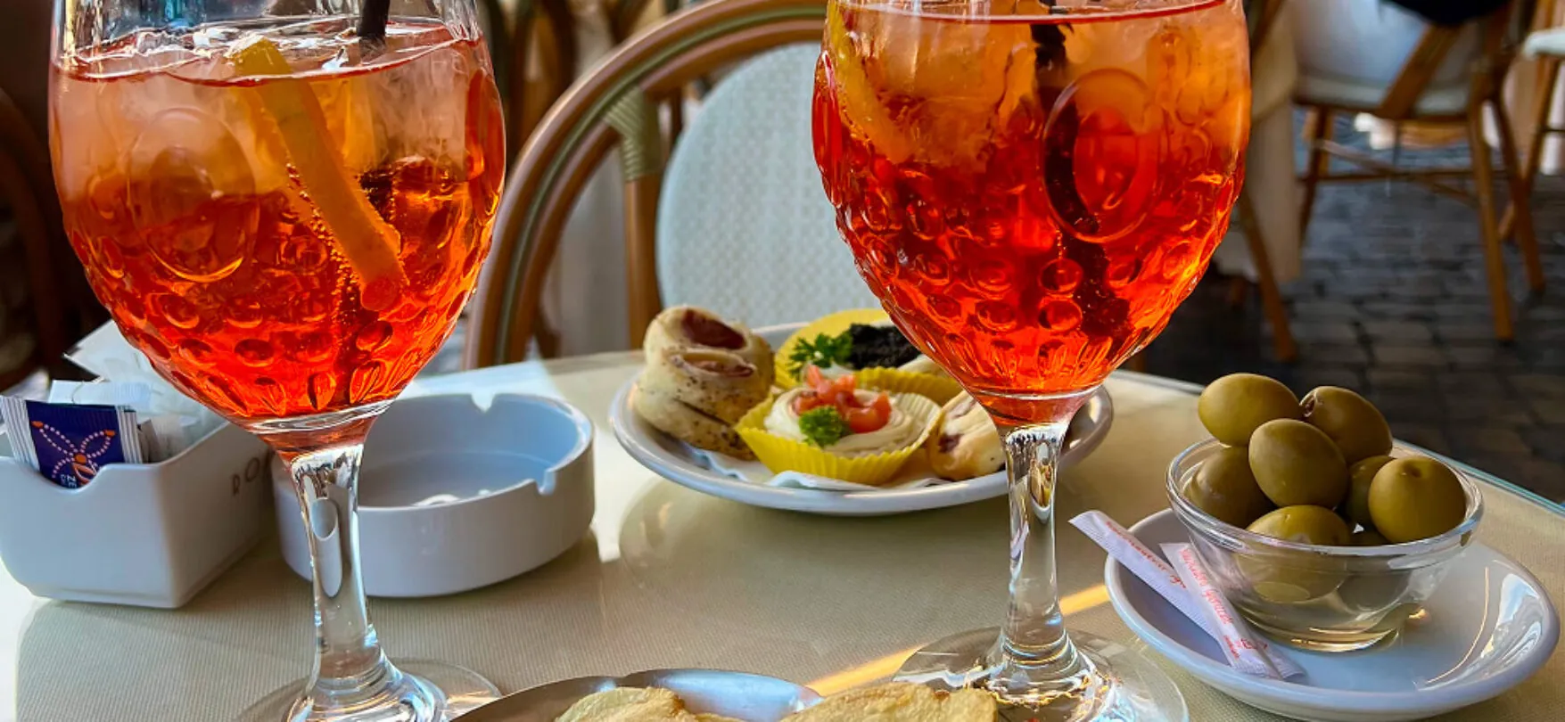 Zwei Gläser Aperol Spritz auf einem römischen Straßencafé-Tisch im Winter
