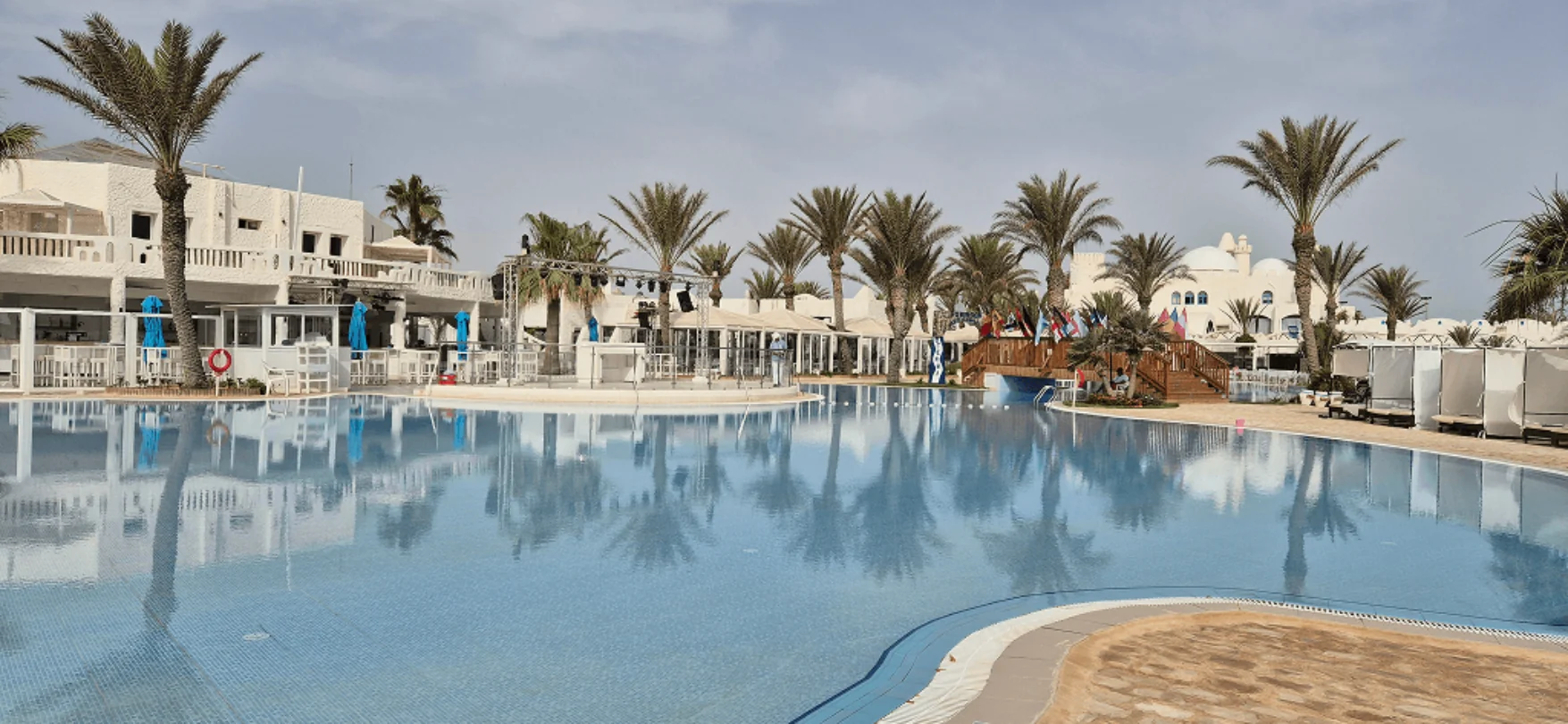 Poollandschaft mit Palmen und Sonnenterrasse in einem Hotel auf Djerba