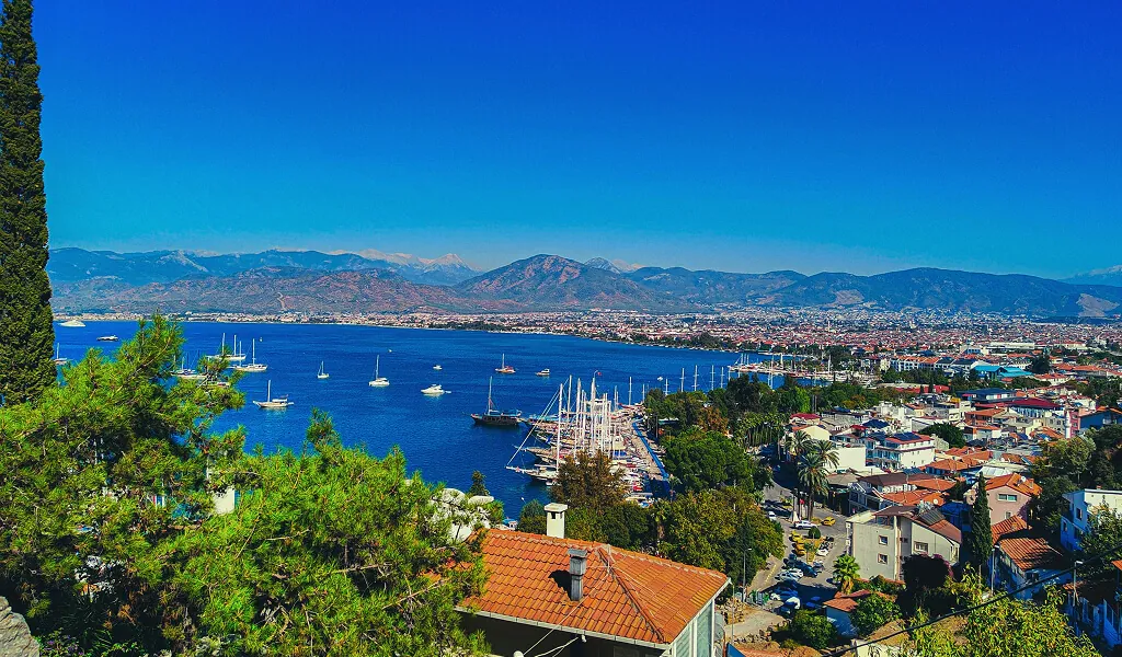 Panoramablick auf den Hafen von Fethiye mit Segelbooten und Bergen im Hintergrund