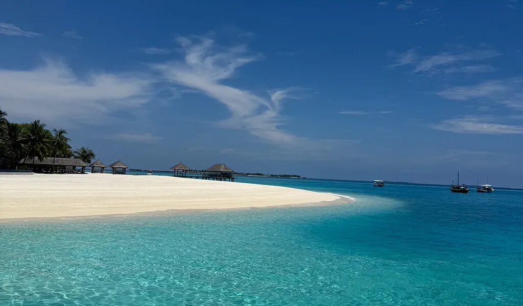 Sandbank auf den Malediven mit türkisblauem Meer und Booten