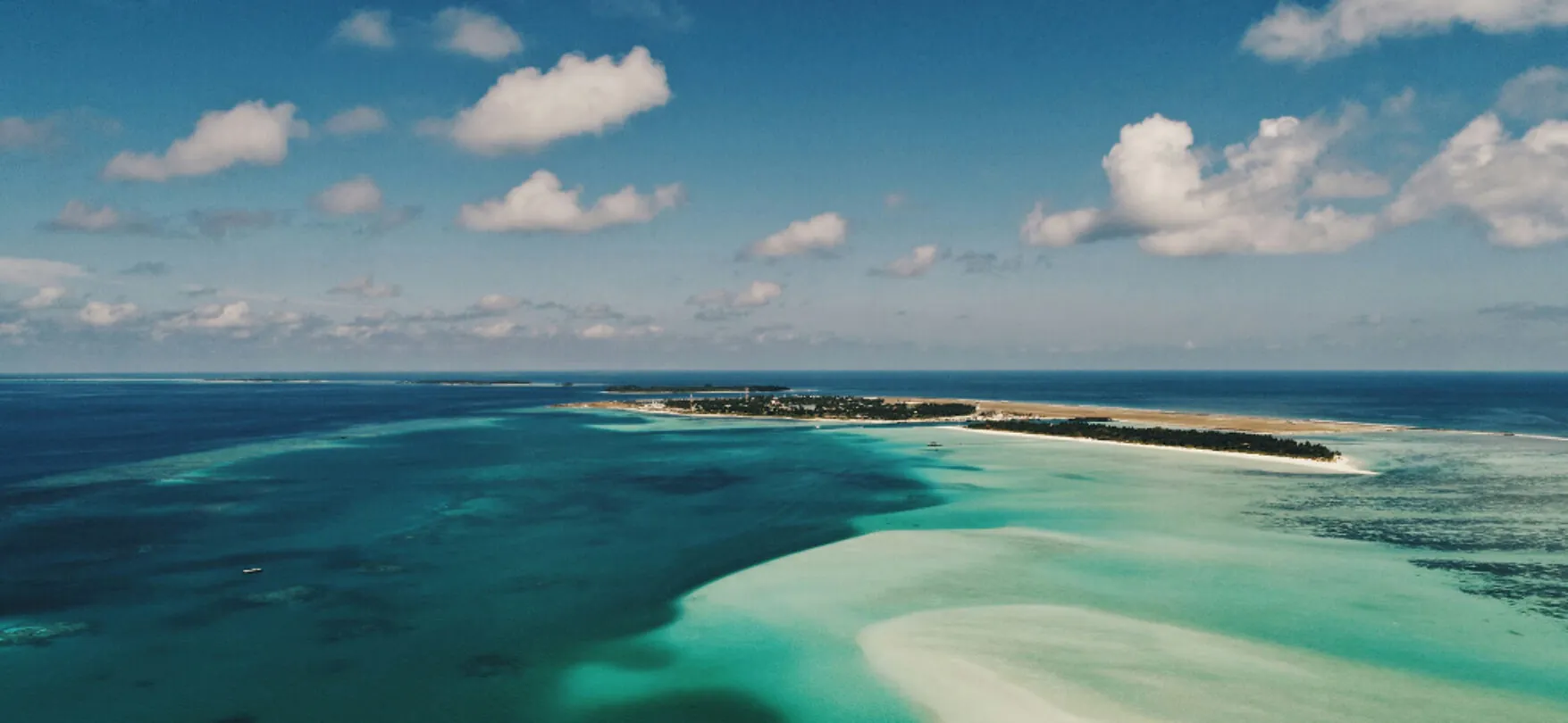Weißer Sandstrand mit Palmen und türkisfarbenem Wasser auf den Malediven