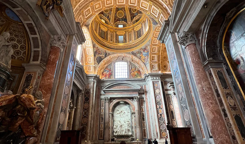 Prächtig verzierte Innenansicht des Petersdoms im Vatikan in Rom mit goldener Kuppel und Marmorverzierungen