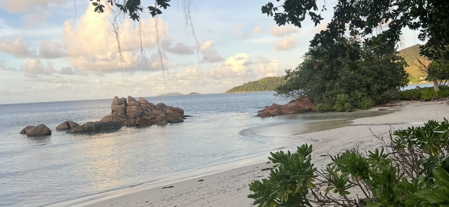 Ruhiger Sandstrand mit Felsen auf Praslin