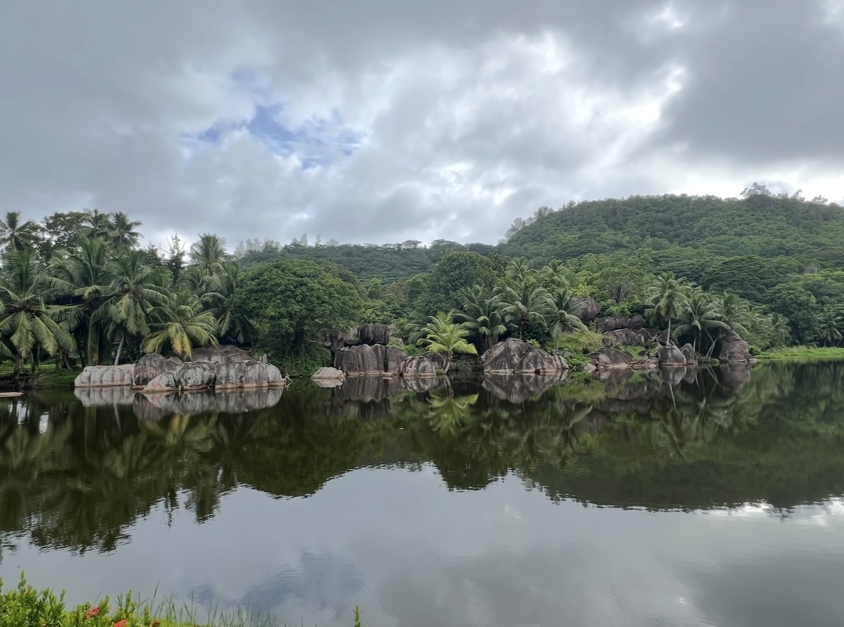 Natur pur auf Mahé – Spiegelung am See mit Felsen Tropische Landschaft mit Felsen und See auf Mahé