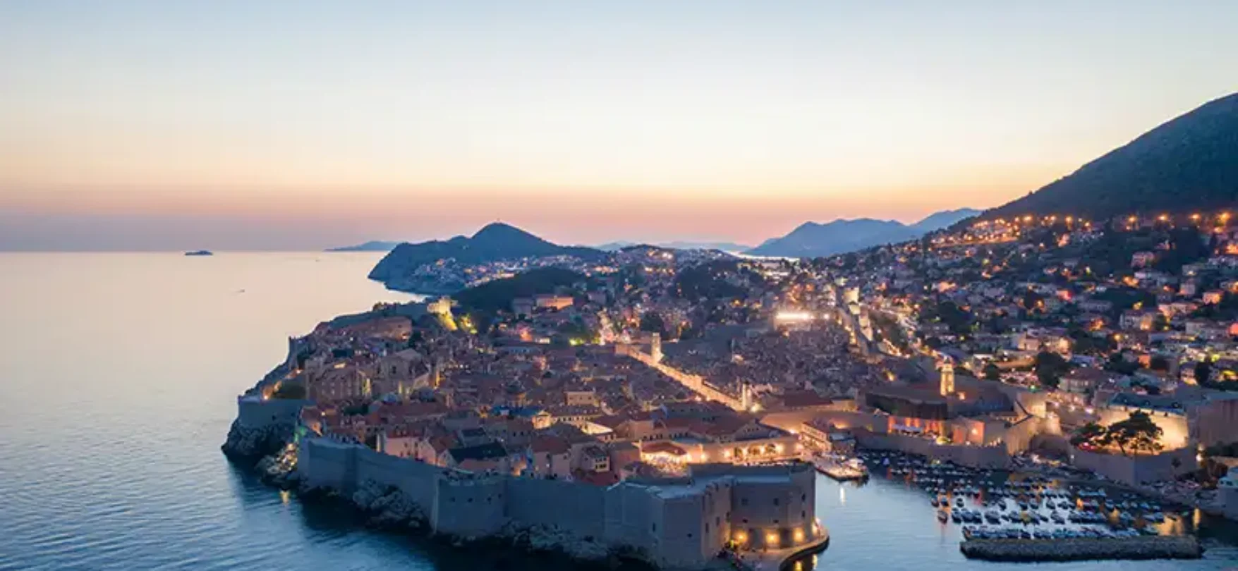 Sonnenuntergang über der beleuchteten Altstadt von Dubrovnik an der Adria