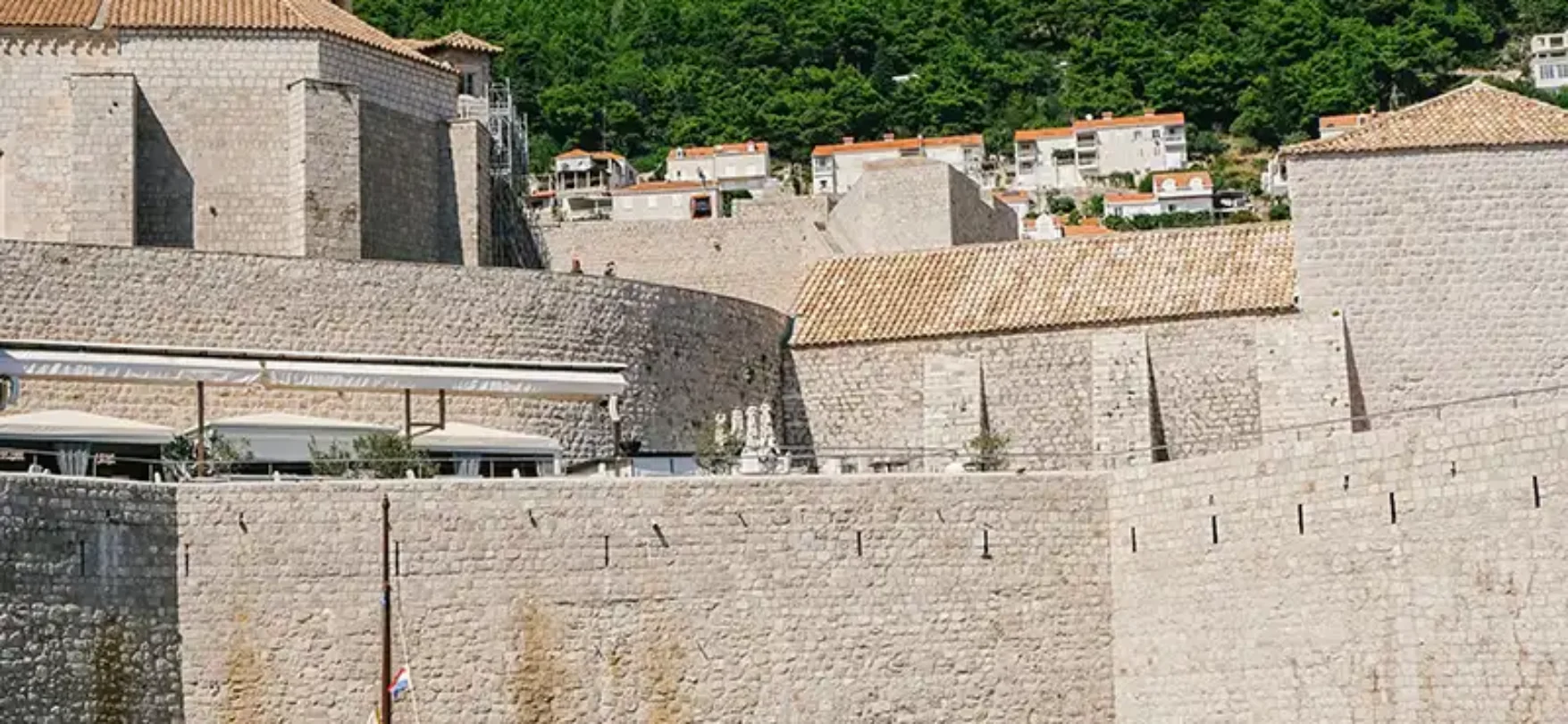 Boote vor der historischen Stadtmauer von Dubrovnik in Kroatien