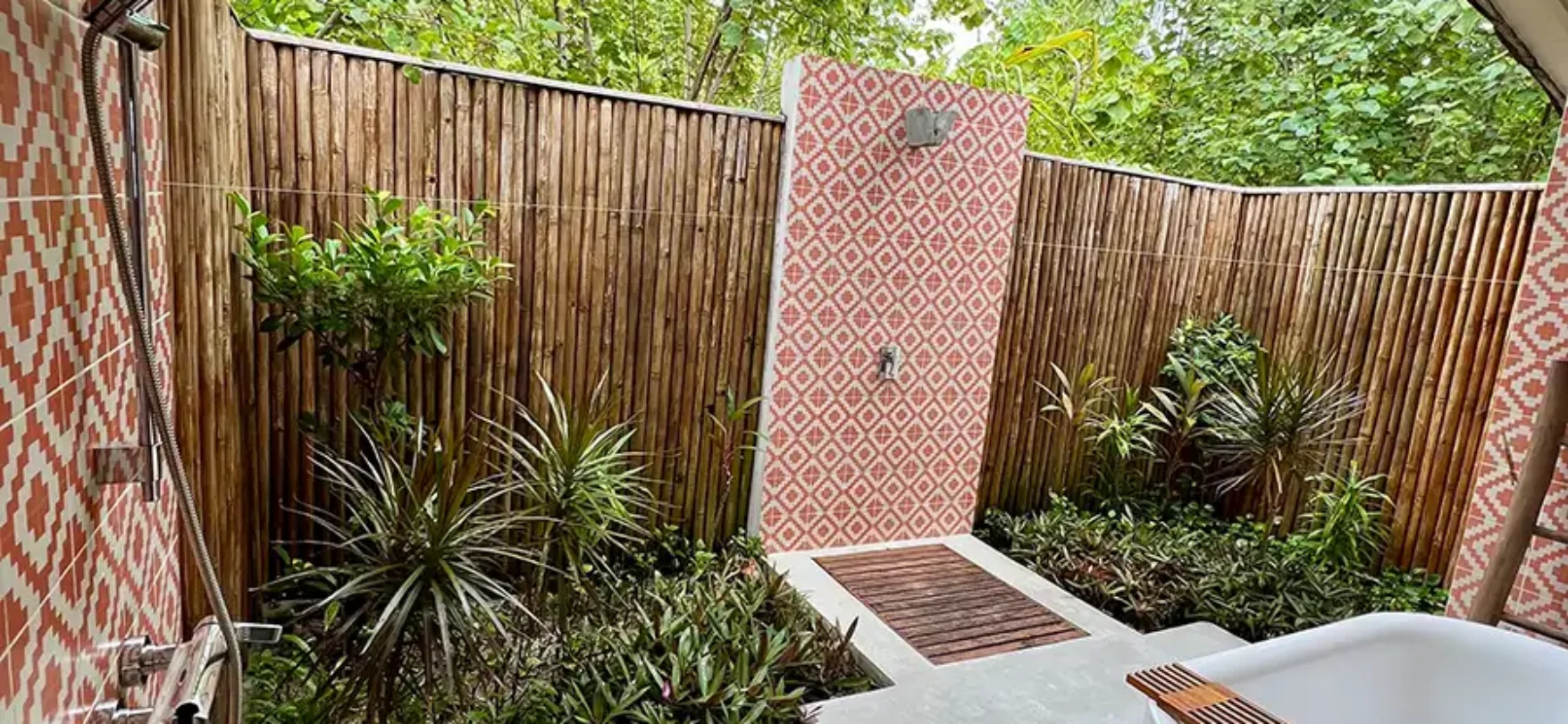 Outdoor-Badezimmer einer Villa im Cora Cora Maldives mit Badewanne und tropischer Dusche