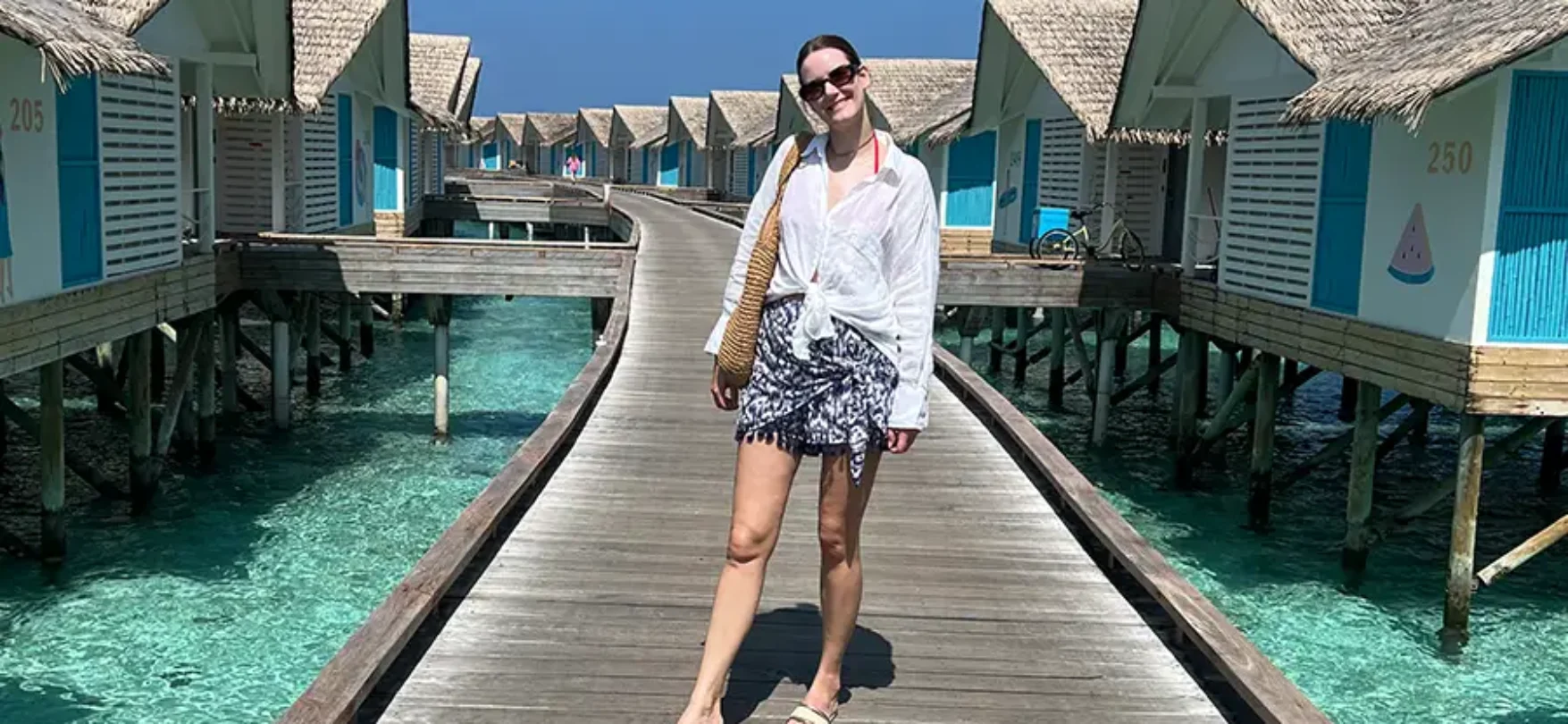 Reiseberaterin auf dem Steg zwischen den Overwater-Villen im Cora Cora Maldives