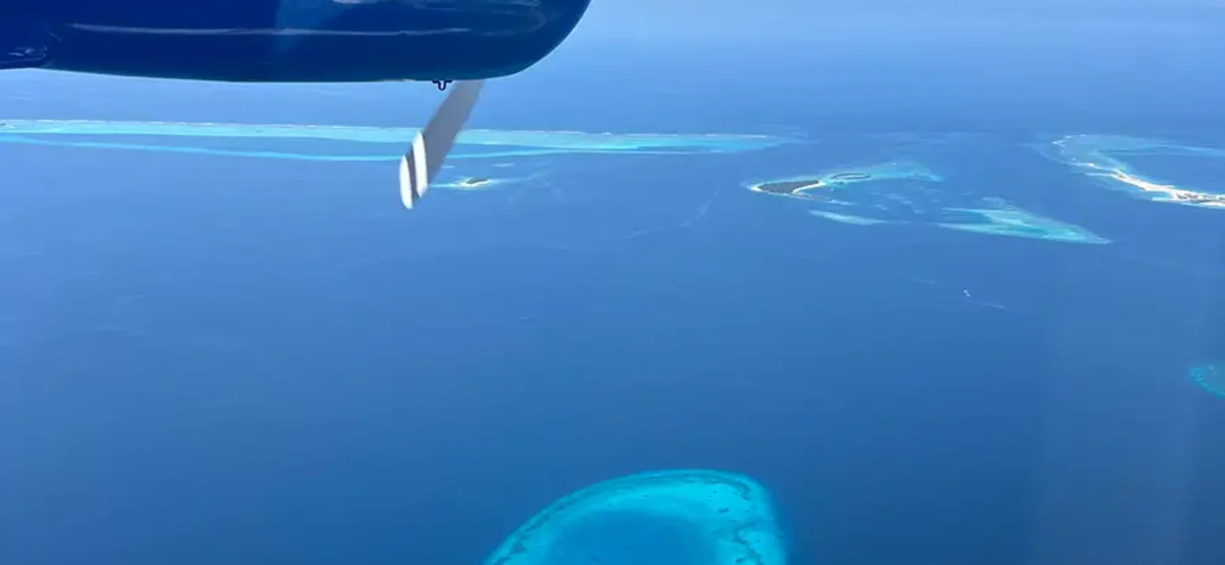 Reisebericht Honeymoon Malediven: Blick aus dem Wasserflugzeug auf türkisfarbene Atolle im Indischen Ozean