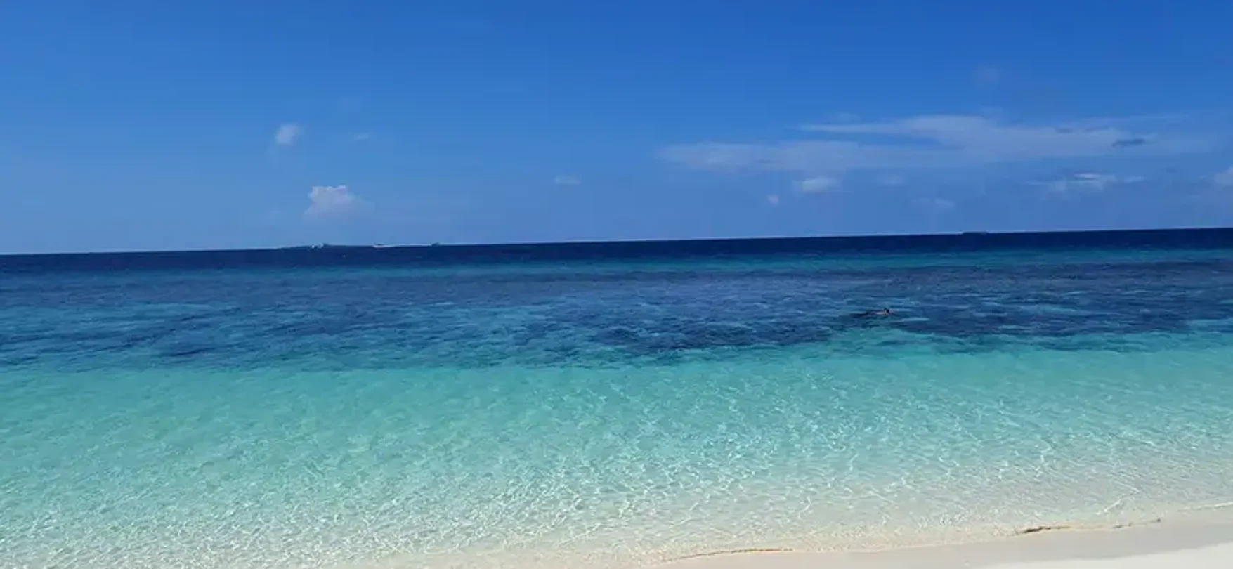 Weißer Sandstrand und türkisfarbenes Meer auf den Malediven im Cora Cora Maldives